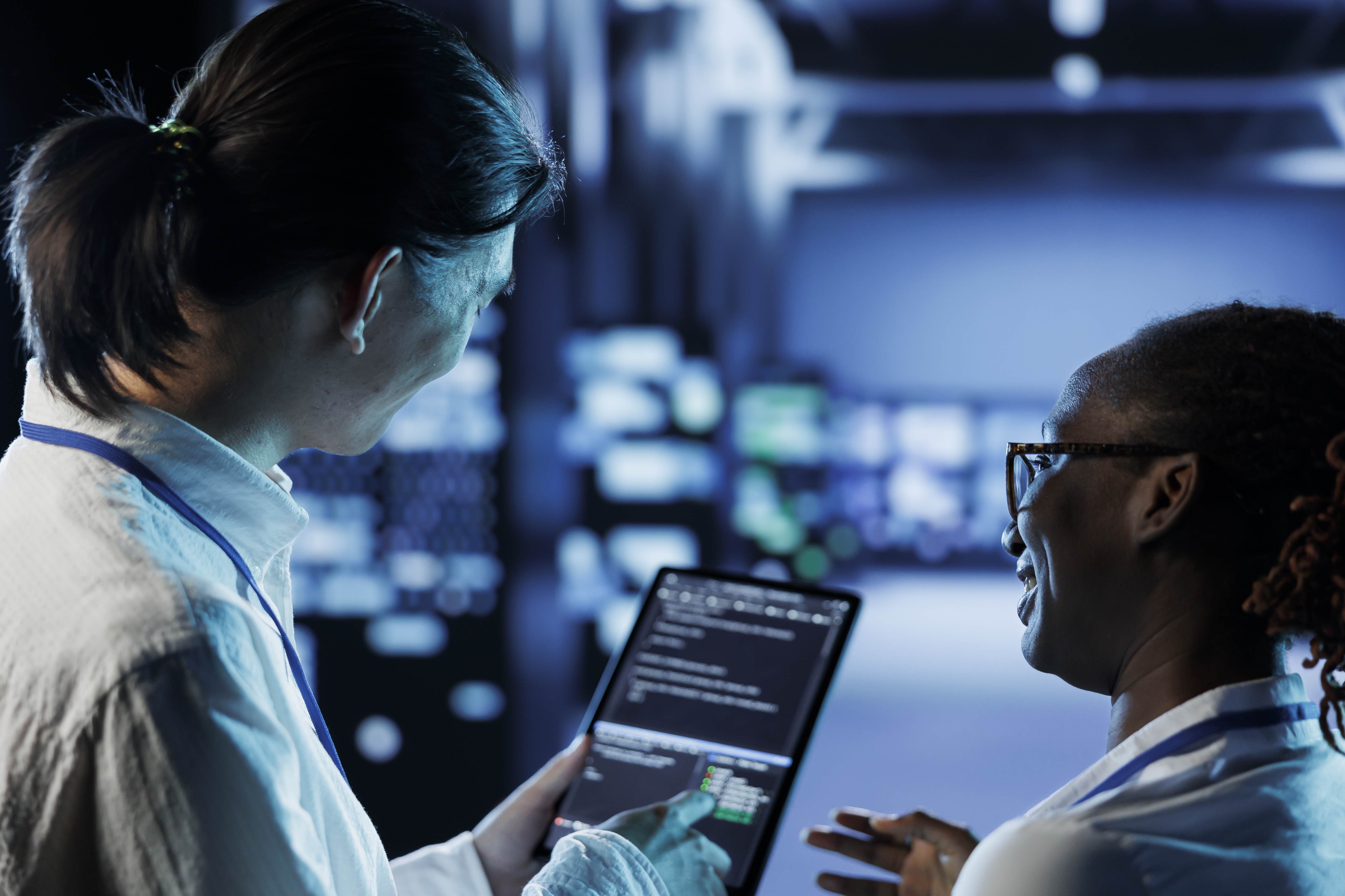Two cybersecurity professionals analyzing network data on a tablet