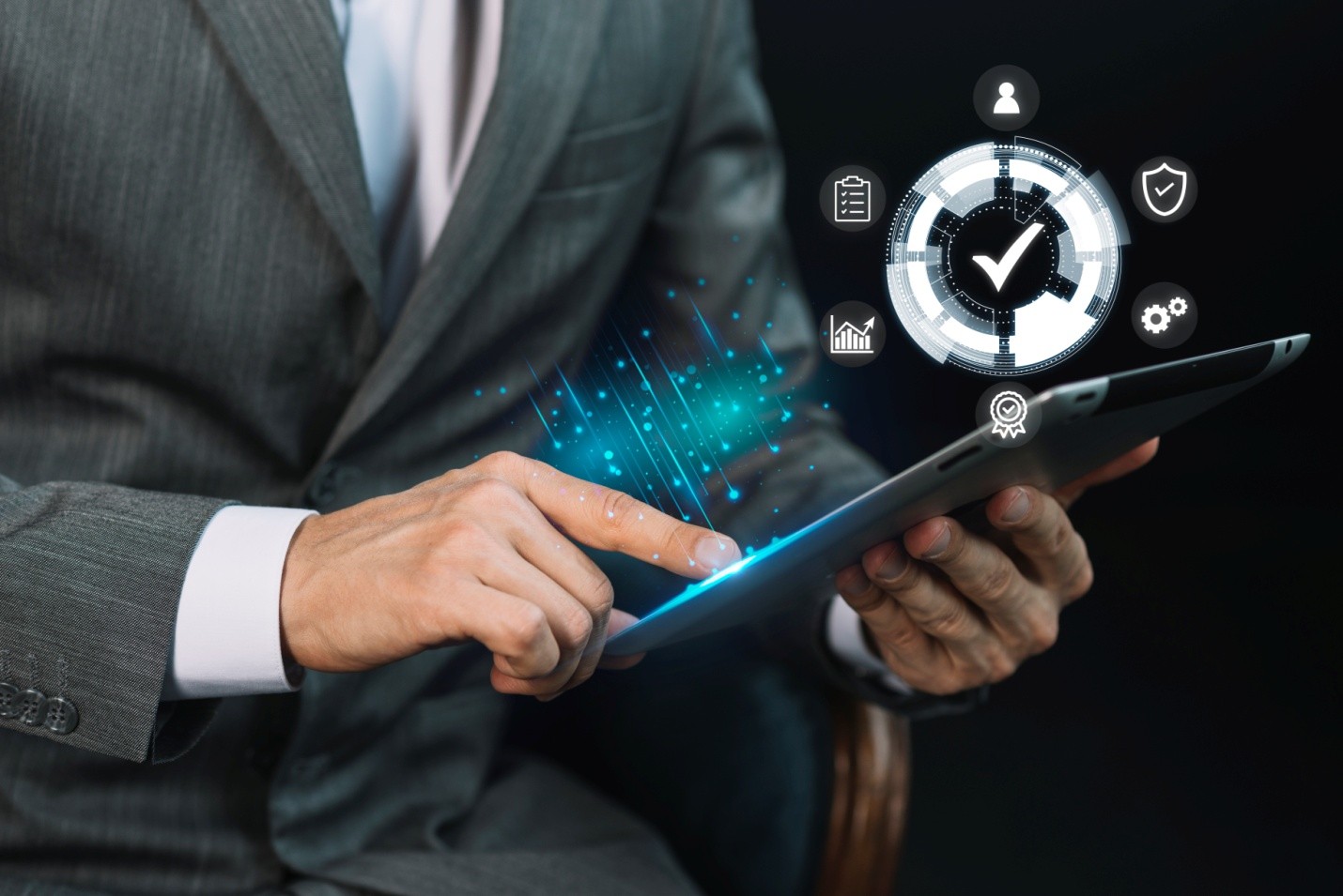 Business professional using a tablet with cybersecurity icons, representing real-time network performance management solutions